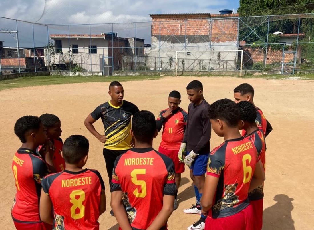 Técnico conversando com os jogadores do time de camisa vermelha antes do jogo